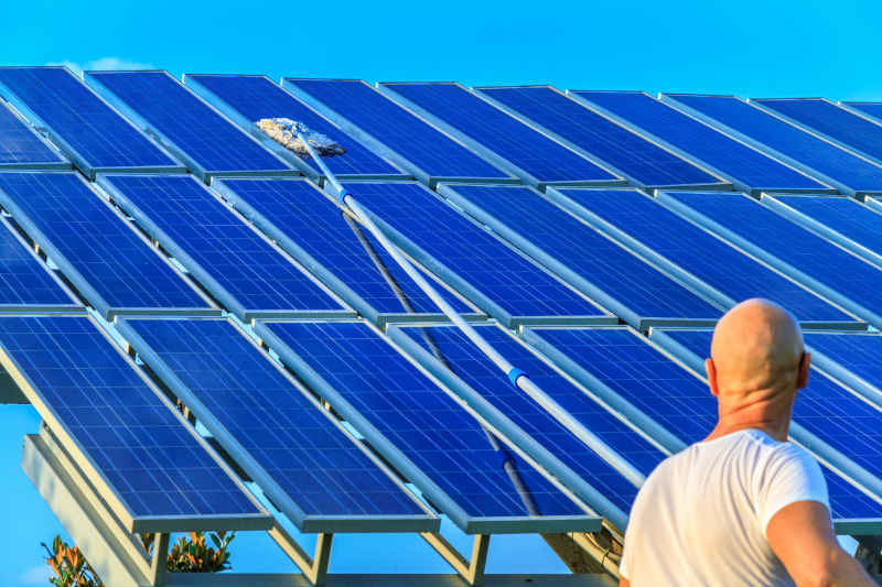 A professional washing a solar panel